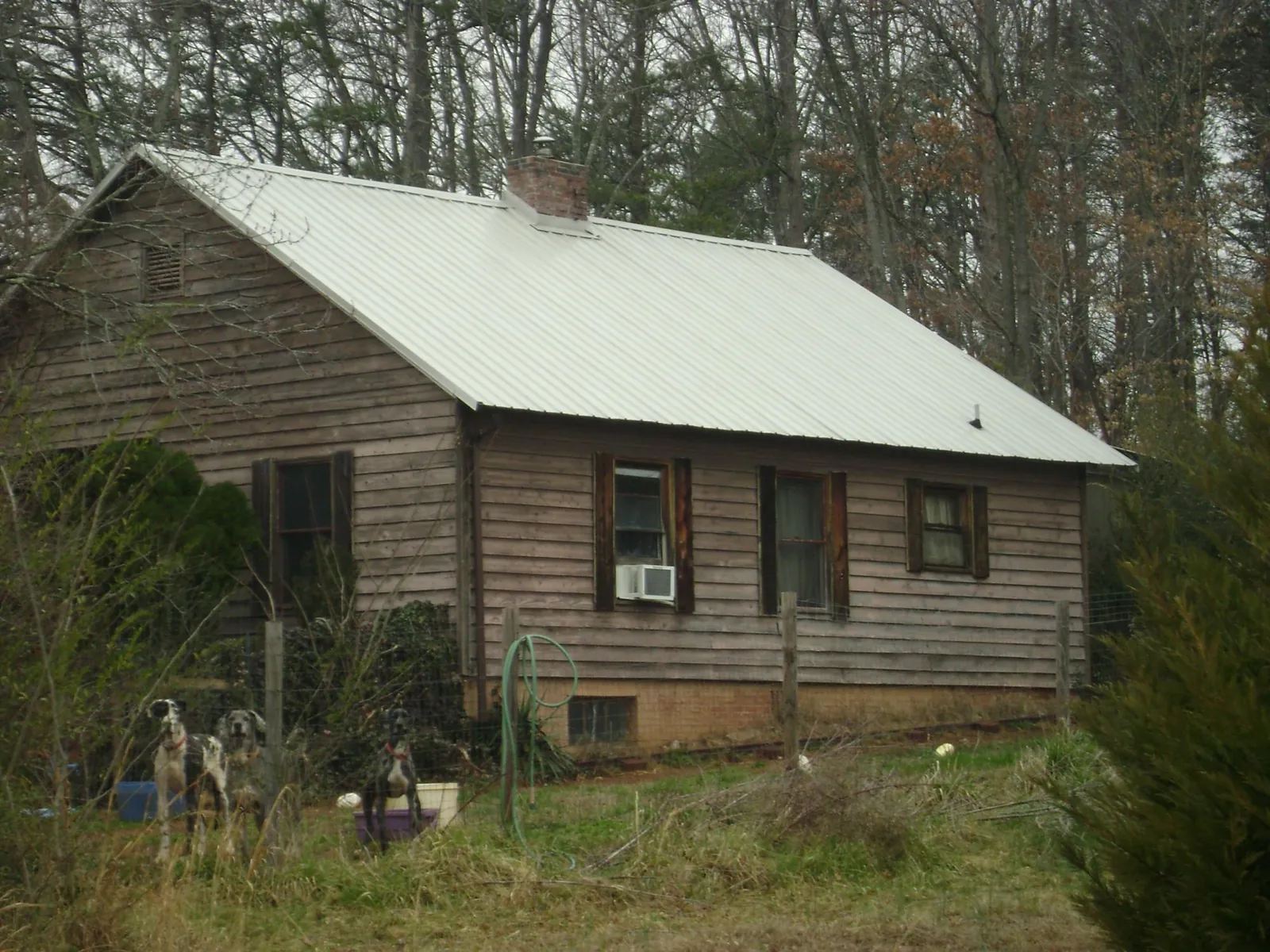 White metal roof on an old wood sided farmhouse, from a Metal Roof Installation job in Collinsville